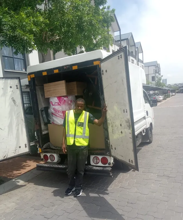 A Lewin Projects team member beside a fully loaded removal truck at a residential estate